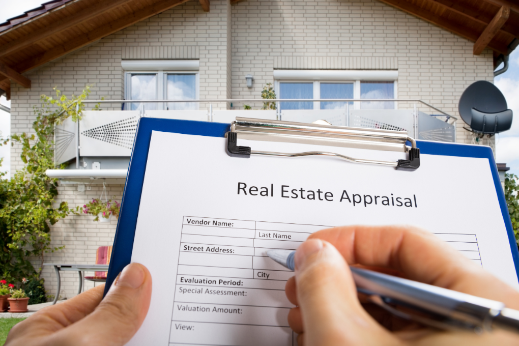 Person filling out real estate appraisal in front of single-family home.