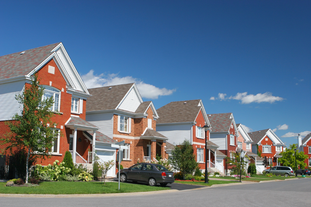 Street view of neighborhood homes on a sunny day.