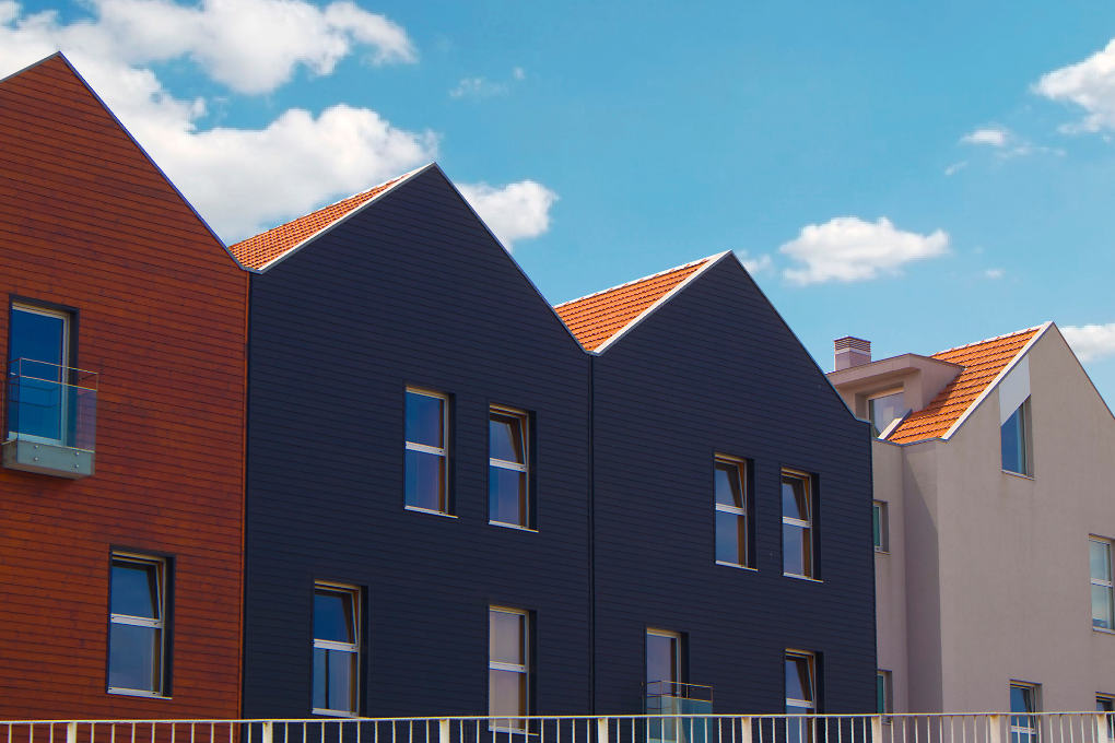 Houses side by side outside with a blue sky.