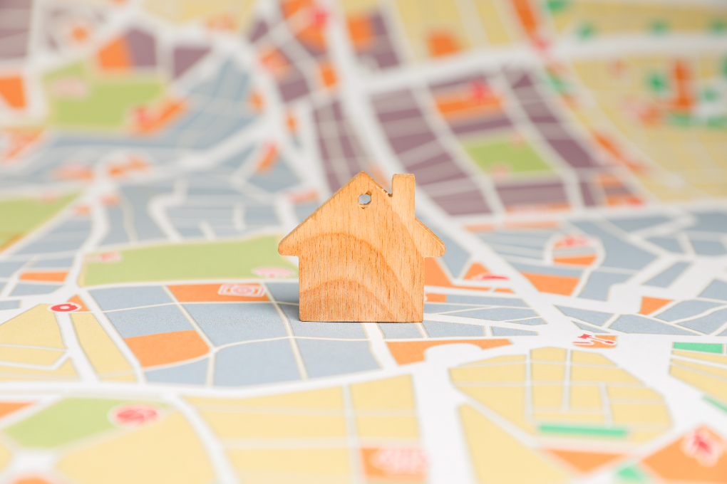 Small wooden house sitting on city map.